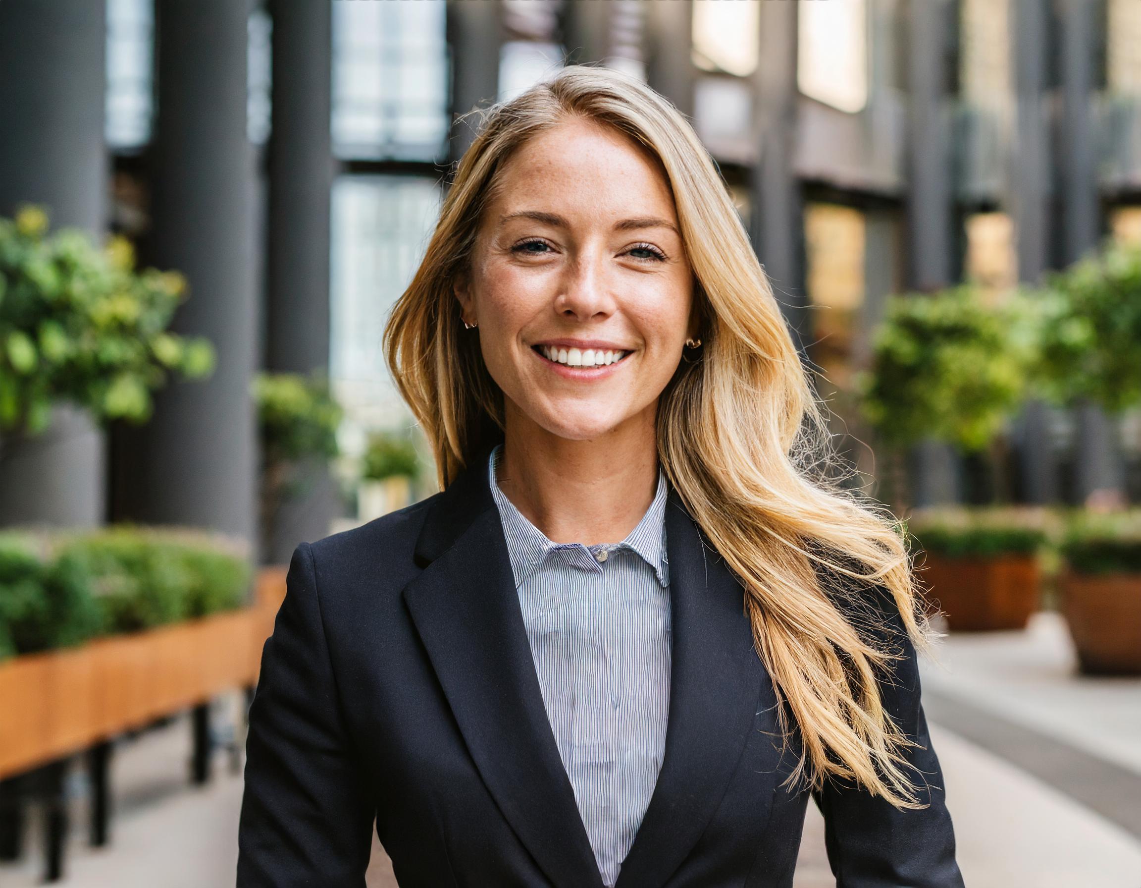 Teammitglied: Anna Weber, lächelnde Frau mit kurzem Haar und formellem Business-Outfit.